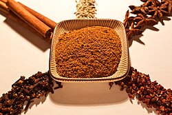 Ingrediënten van vijfkruidenpoeder: szechuanpeper (rechtsonder), kruidnagel, kaneel, venkelzaad en steranijs